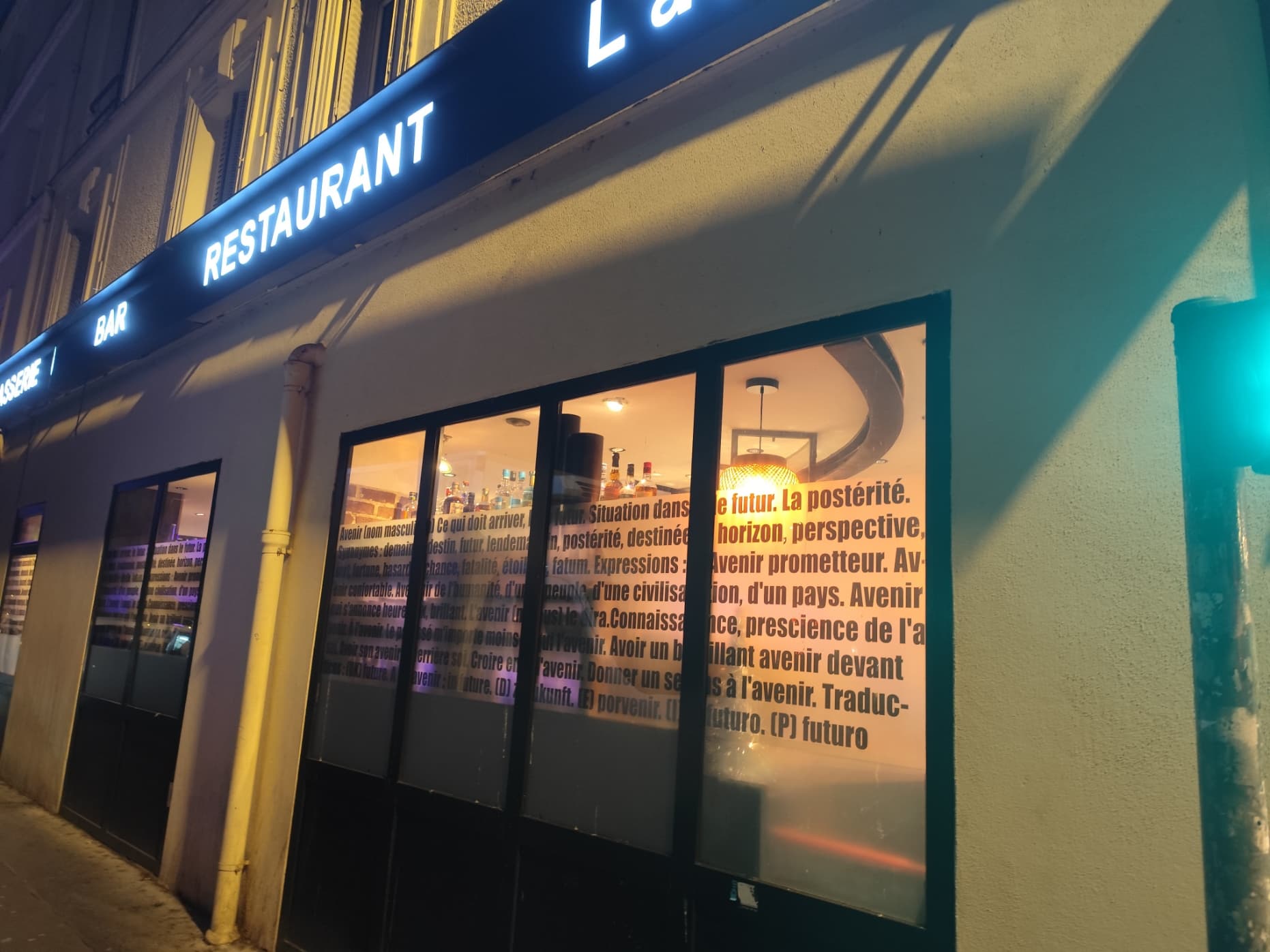 Façade du restaurant de nuit avec enseigne lumineuse